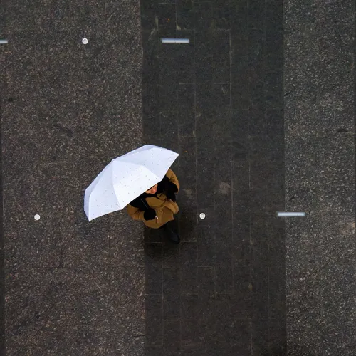 a woman standing under a white umbrella