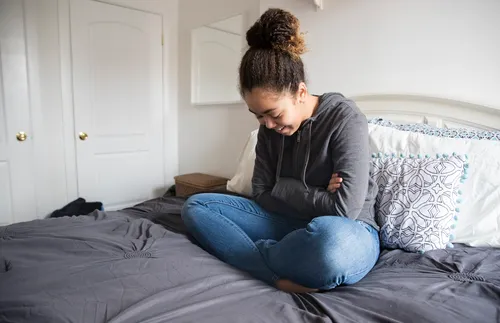 woman sitting on bed and praying