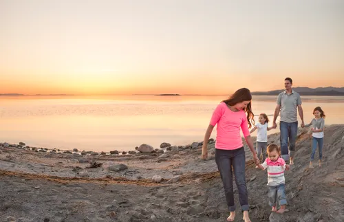 a young family walking along a beach