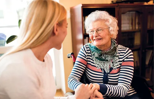 an older woman and a younger woman visiting with each other