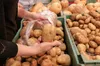 person putting potatos in plastic bag