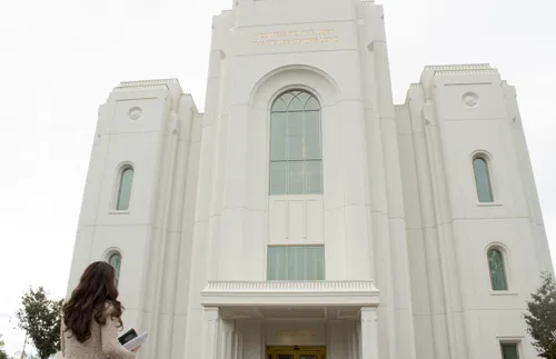 a young woman looking at the temple and thinking about her covenants