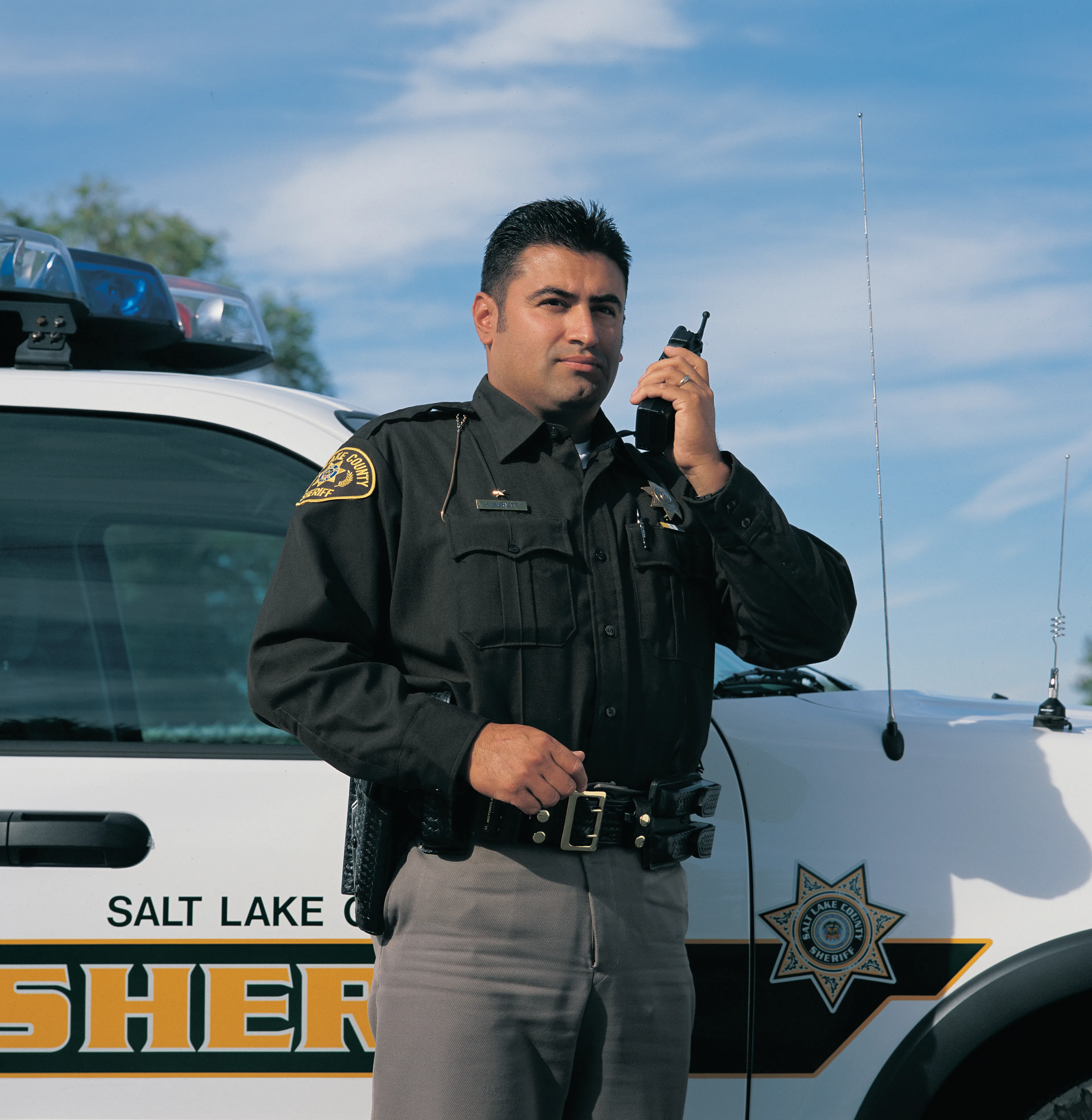 A police officer standing next to his vehicle.