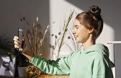 young adult woman holding a phone