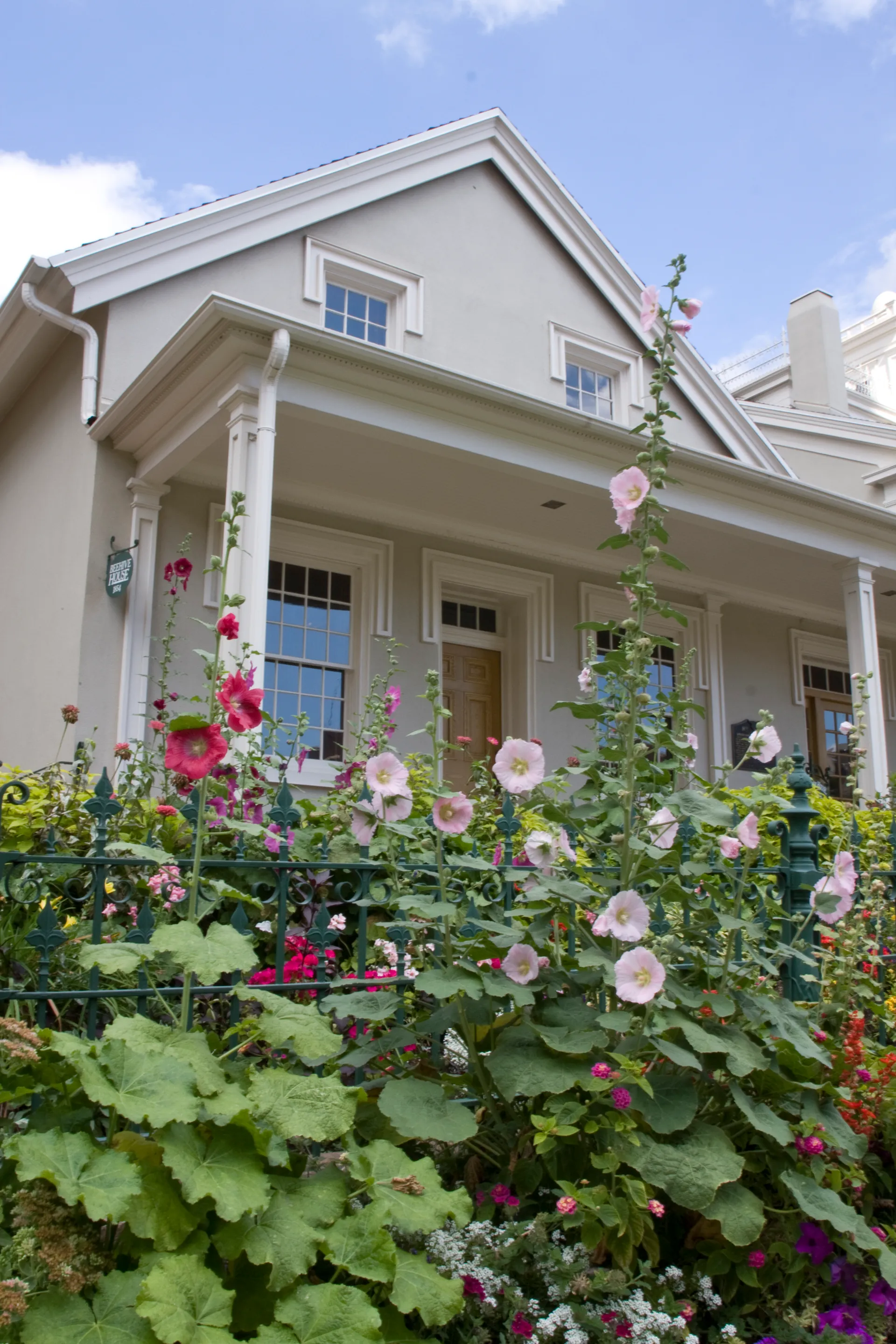 The Beehive House surrounded by hollyhocks in Salt Lake City, Utah.
