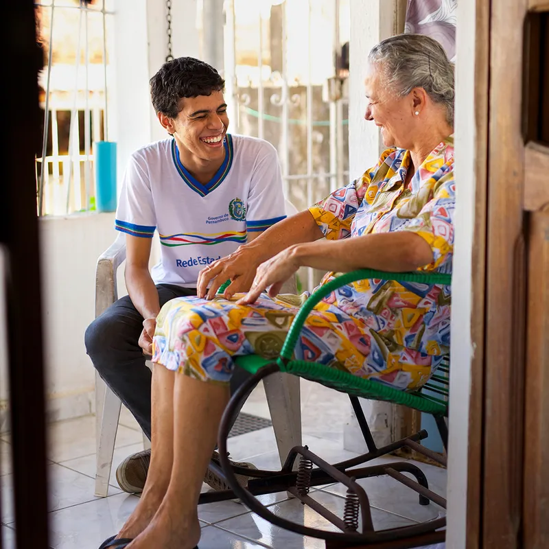 A grandson visits his grandmother on her front porch