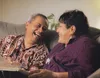 Polynesian couple on a couch with a photo album.