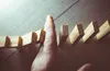 fingers stopping dominoes from falling