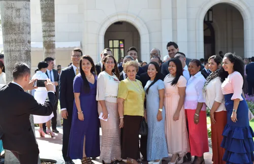 members posing for a photo outside a temple