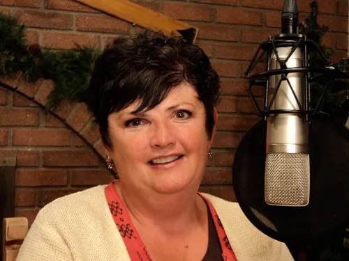 A woman beside a radio microphone.