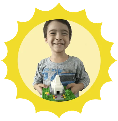Headshot of a little boy holding a block temple