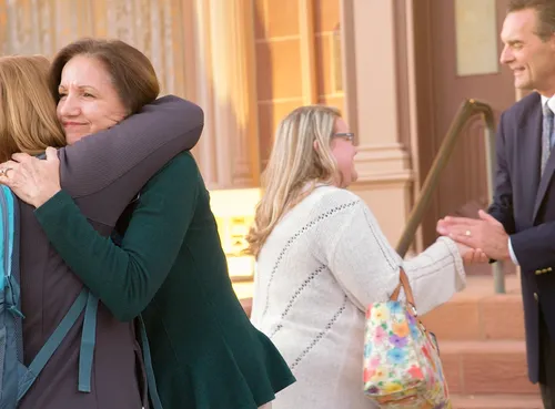 folk krammer og giver hånd