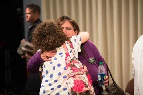 Men and women meeting together in an addiction recovery program.