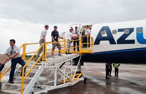 missionaries helping to unload emergency supplies from airplane