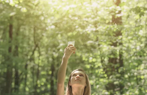 a woman holding her phone up and trying to get better cell reception