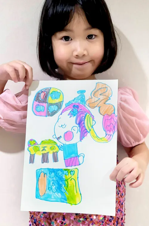 girl holding drawing of child praying