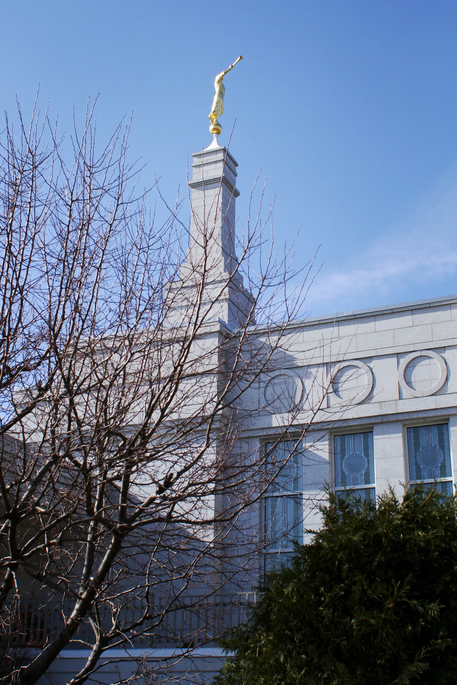 A side view of the St. Paul Minnesota Temple, including the spire, windows, and scenery.