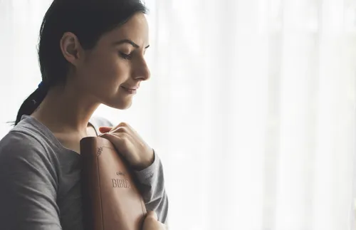 woman holding scriptures close to her