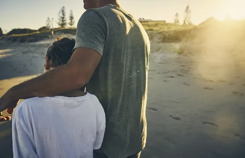 father with arm around son