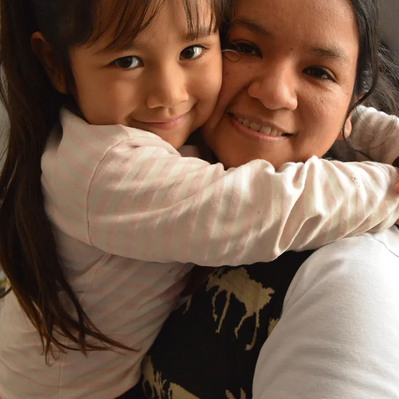 A mother holds her daughter in her arms