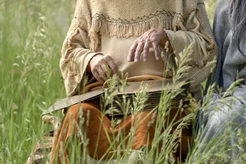 Lehi holds the plates while teaching his family.