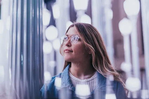 Young adult woman looking up at lights