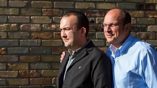 two men standing by wall