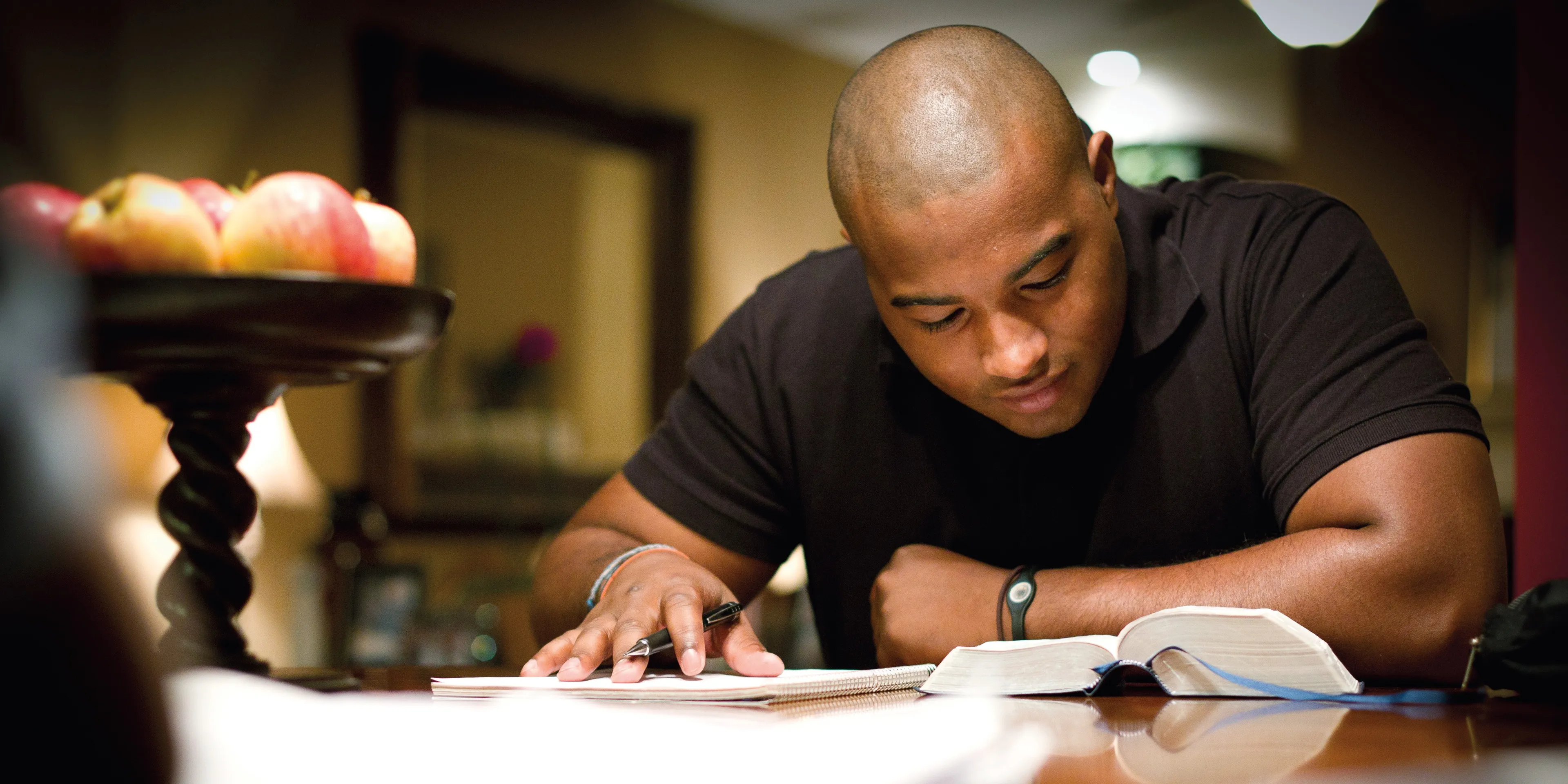 A man studying the scriptures at a table.