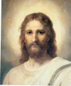 Frontal head and shoulders portrait of Jesus Christ. Christ is depicted wearing a pale red robe with a white and blue shawl over one shoulder. Light emanates from His face.