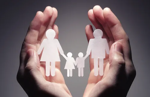 paper doll family in cupped hands