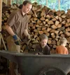 man and boys with woodpile
