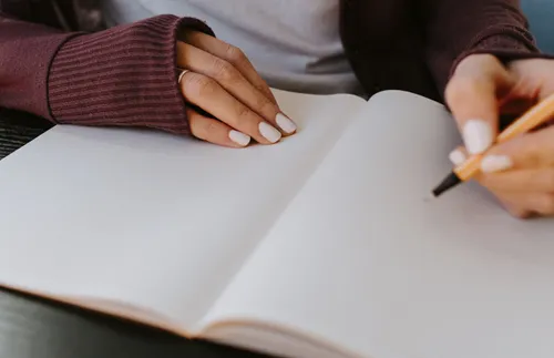 woman writing in a blank notebook