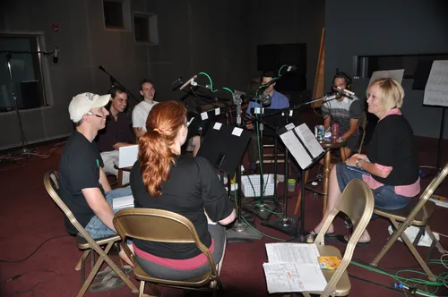 A group of people sitting around music stands.