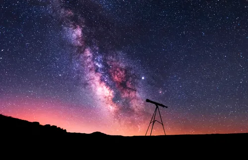 a bright, beautiful constellation behind a telescope