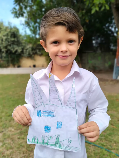 boy holding a cut-out drawing of the temple