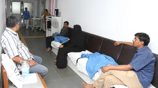 LDS Charities Vision Care program. Hallway inside an Eye clinic located Hyderabad, India.  Group of Nurses or doctors in a hallway in a medical facility in India, parents sitting and possibly waiting for children in surgery.(Ophthalmic Plastic Surgery and Ocular Oncology Service, LVPEI, Hyderabad, India)   ophthalmologyIndia-operating room