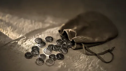 a small leather bag with silver coins