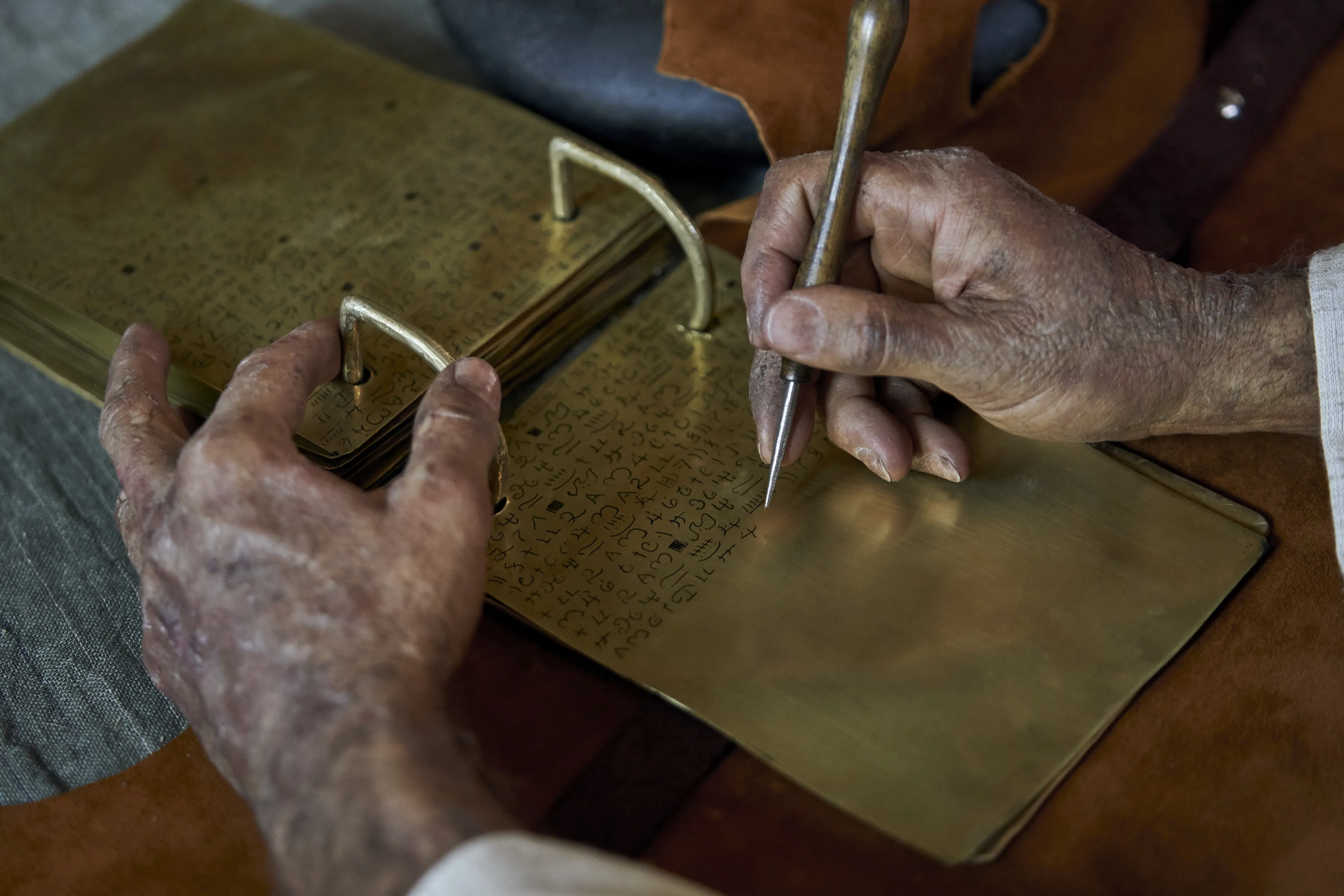 Jacob engraves on metal plates.