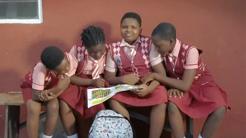 group of children looking through magazine