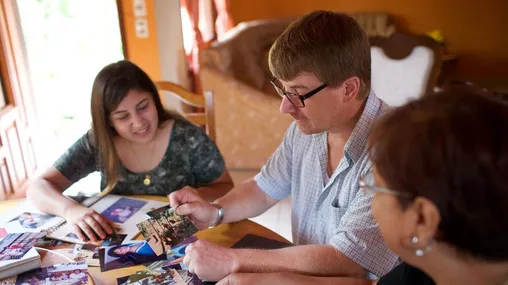 Paraguay. A family sitting around a table looking at family photographs.