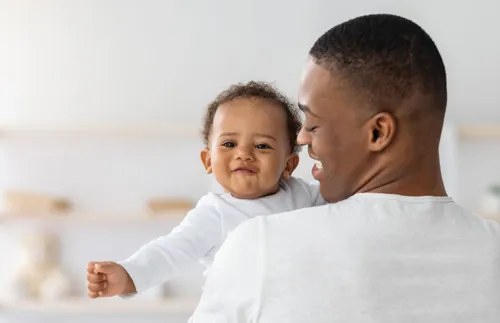 man smiling and holding a young child