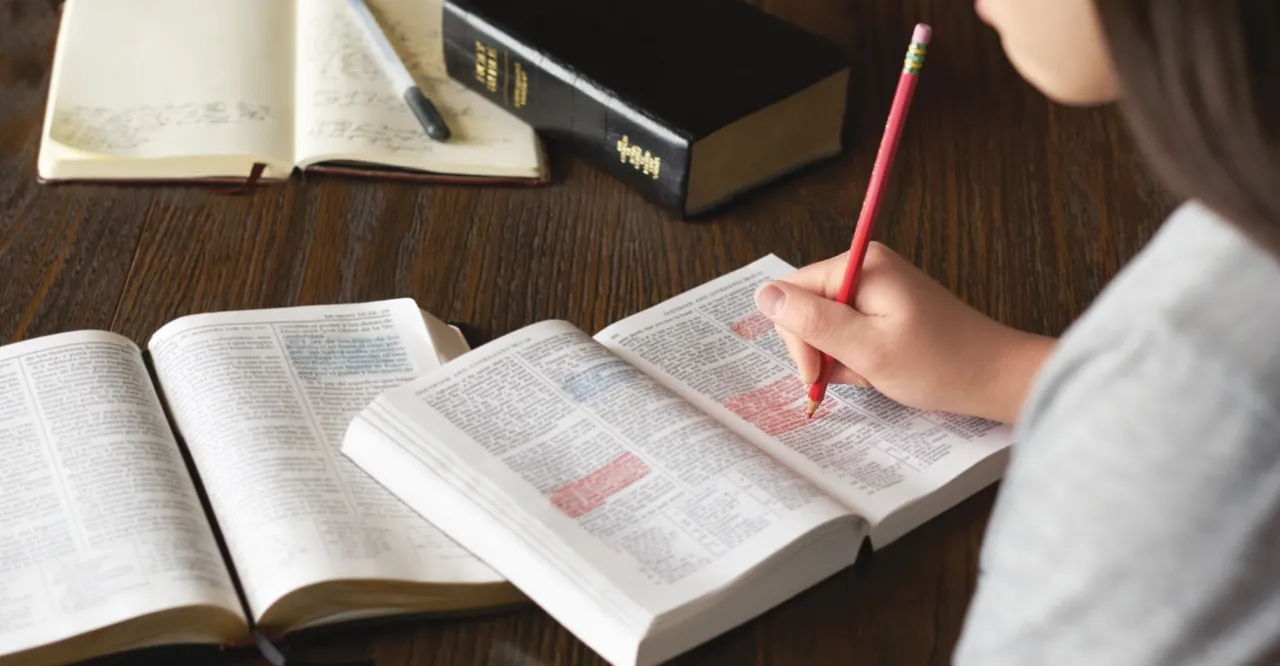 Girl marking her scriptures at table