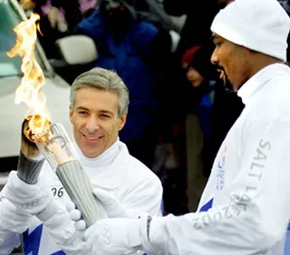 Dale Hull lighting the Olympic torch with Utah Jazz player Karl Malone..
