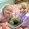 Photo of two girls smiling with a Resurrection garden they made