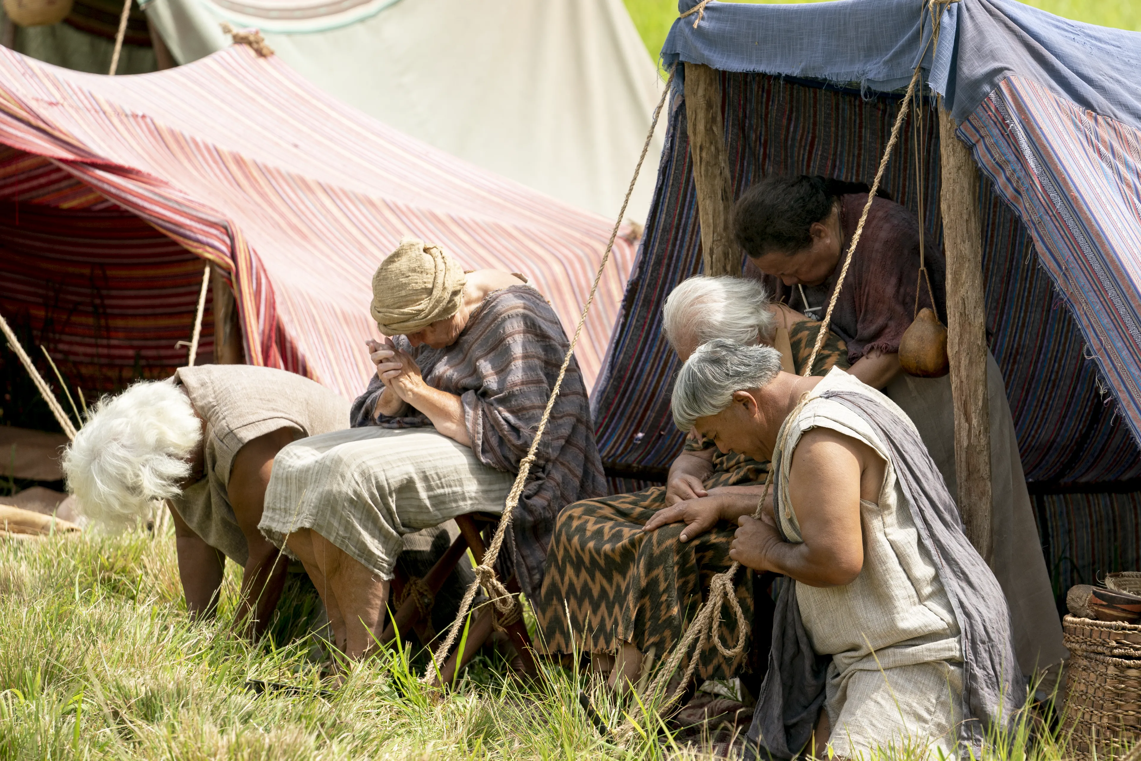Men and women gather and kneel as they listen to King Benjamin in the Land of Zarahemla.