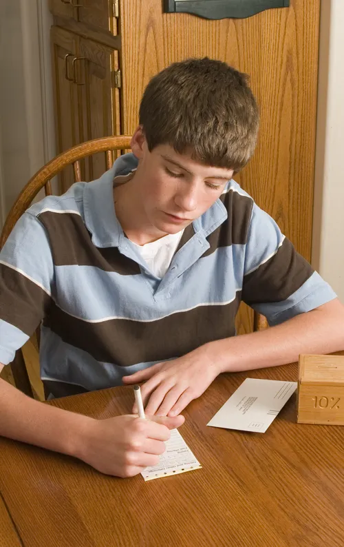 young man writing on donation slip
