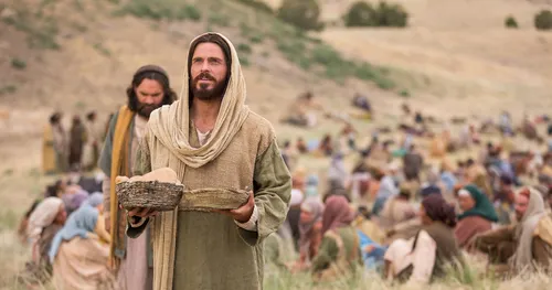 Jesus blessing bread he is about to feed to the gathered multitude.