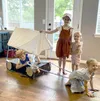 Children dressed as pioneers with a homemade covered wagon