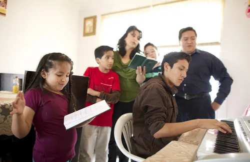 family singing around a piano