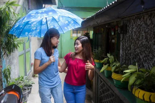 two girls walk together down a street